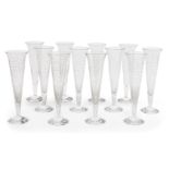 A set of twelve Baccarat champagne flutes, each designed with scrolling leaf motifs, to tapering