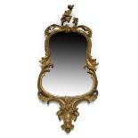 A gilt wood Rococo taste wall mirror, late 18th/early 19th Century, of waisted form, with carved