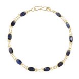 A sapphire bracelet, composed of a line of oval sapphire collets with chain link connections, length