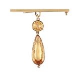 An early 19th century topaz pendant, the pear shaped pale orange topaz drop with oval pale orange