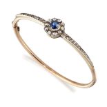 A late 19th century sapphire and diamond bangle, of hinged half-hoop design, the oval sapphire and
