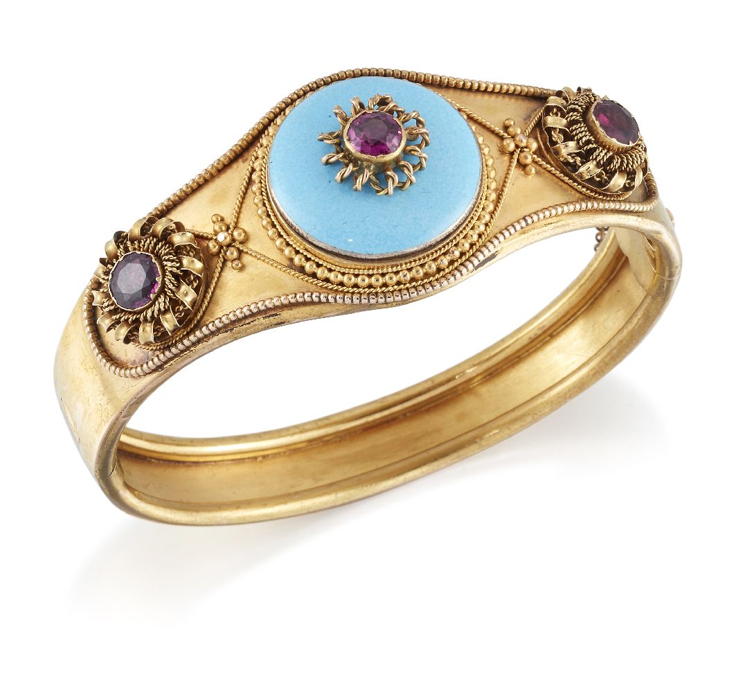 A late Victorian gold, enamel and garnet bangle, the tapered hinged half-hoop set to the front