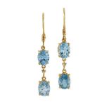 A pair of topaz and diamond earrings, each composed of two oval blue topaz with brilliant-cut