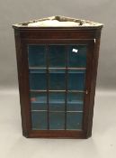 A George III mahogany glazed hanging corner cabinet,