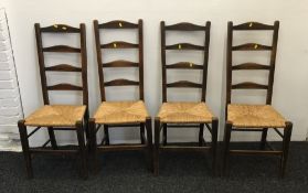 A set of four rush seated oak ladder back chairs