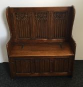 An oak linen fold settle. 37 inches wide; 17 inches deep; 40 inches high.