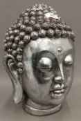A silver coloured bust of Buddha