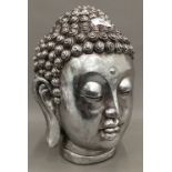 A silver coloured bust of Buddha