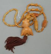 A Chinese carved hardstone necklace with fish pendant