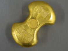 A golden coloured scroll weight