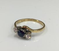 An 18 ct gold diamond and sapphire crossover ring (2.