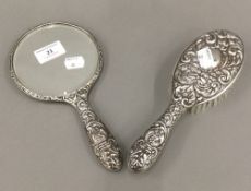 A silver backed brush and hand mirror