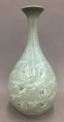 A celadon vase decorated with birds amongst clouds