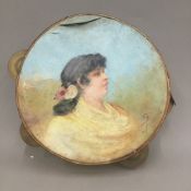 A tambourine painted with a young lady