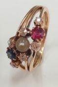 An unmarked gold ruby, sapphire, diamond and pearl ring (4.3 grammes total weight). Ring size L/M.