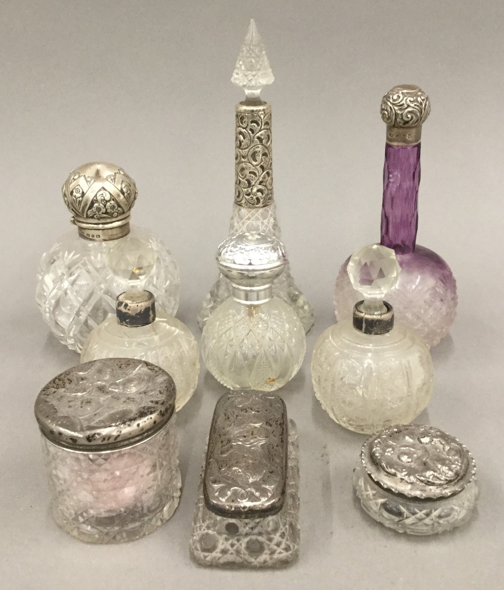 A collection of silver mounted cut glass scent bottles