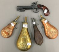 Four powder/shot flasks and a modern replica pistol