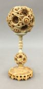 A late 19th/early 20th century Chinese carved ivory puzzle ball on stand. 19 cm high.