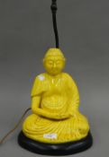 A late 19th/early 20th century yellow glazed pottery model of Buddha formed as a lamp