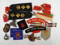 A quantity of military cap badges, etc.