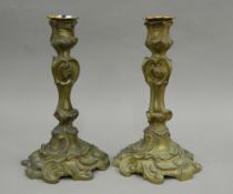 A pair of 19th century brass rococo style candlesticks