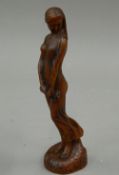 A small Art Nouveau style wooden figure of a girl