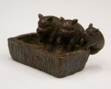 A bronze model of pigs at a tough