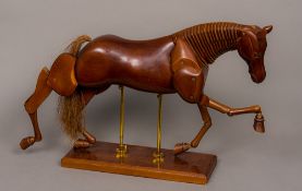 A carved wooden articulated horse, naturalistically modelled,