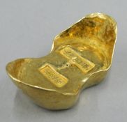 A gold coloured scroll weight