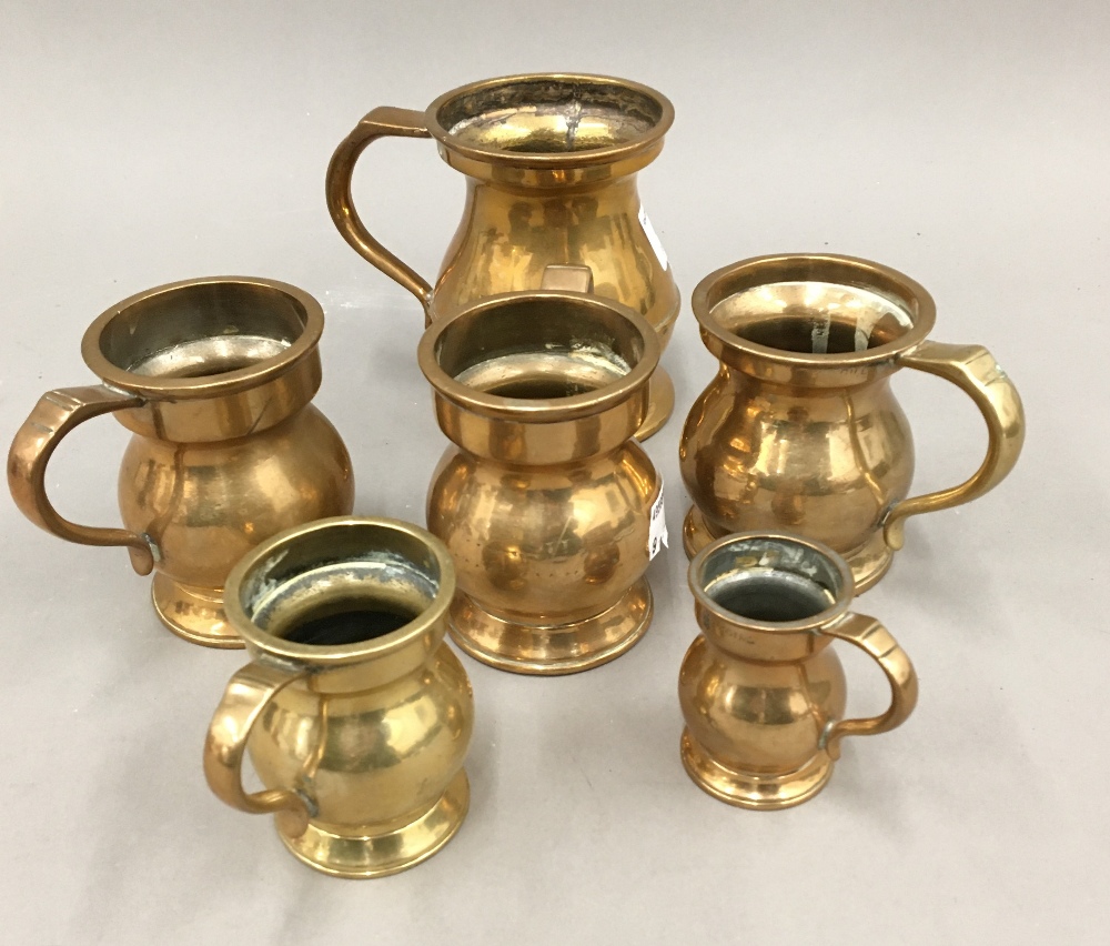 Six graduated brass and bronze pub measures (1/4 gill, half gill,