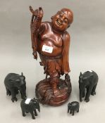 A Chinese carved wooden model of Buddha and four carved ebony elephants