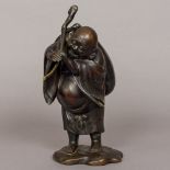 A Japanese Meiji period figure of Buddha Modelled standing in open robes holding a staff and with a