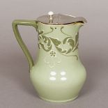 A Moorcroft Macintyre Esso faience jug The green glazed body with scrolling floral decoration.