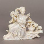 A Chinese carved hardstone figure of Guanyin Modelled seated holding flowers with a further vase of