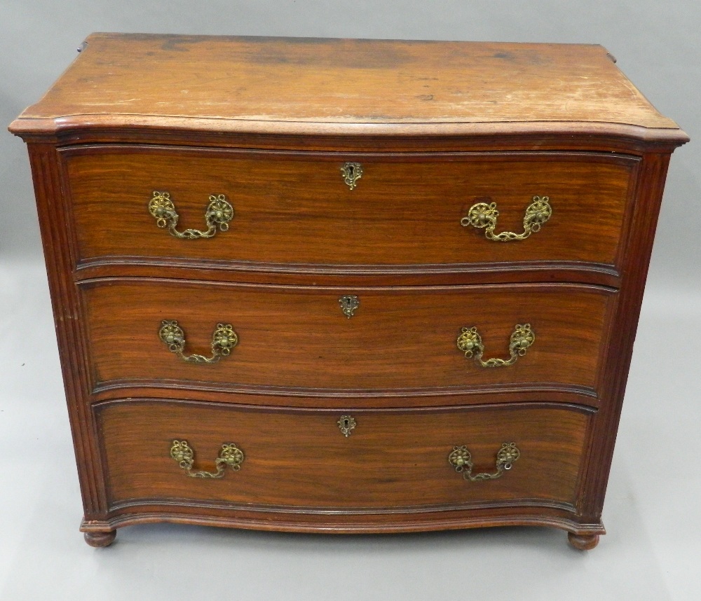 A George III mahogany serpentine chest of drawers The eared shaped top above three drawers flanked
