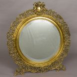 A large 19th century pierced brass strut mirror The circular bevelled mirror plate surrounded by