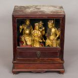 Four 19th century Chinese gilt heightened carved wooden figures Housed in a Chinese glazed hardwood