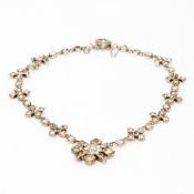 An unmarked paste set white metal necklace Centrally set with a star form drop. 34.5 cm long.