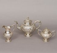 A Chinese three piece silver tea set Each piece with embossed dragon decorations,