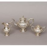 A Chinese three piece silver tea set Each piece with embossed dragon decorations,