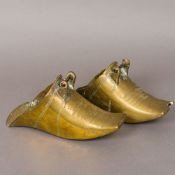 A pair of antique brass stirrups Of typical form, possibly South American. Each 27 cm long.