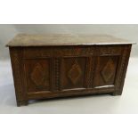 A 17th century oak coffer The rectangular plank top above a lunette carved frieze and three panels,