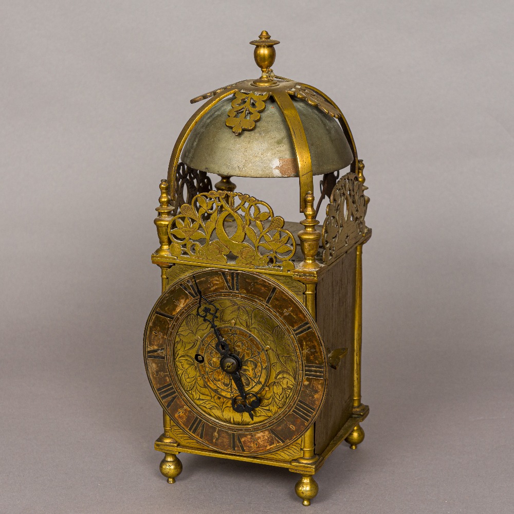 A brass lantern clock The case of typical form with finial mounted top above a bell and circular