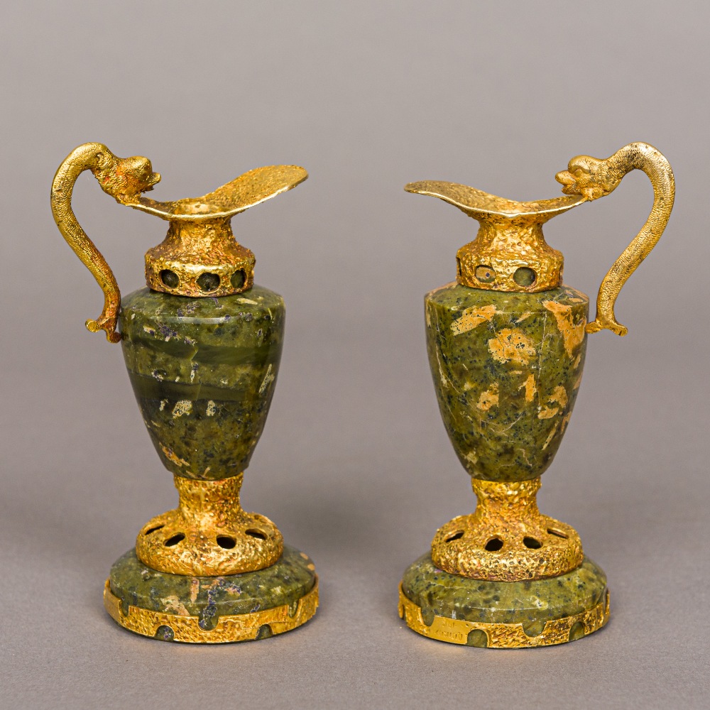 A pair of 14K gold mounted hardstone ewers Each with stylised dolphin form handle. Each 12 cm high.