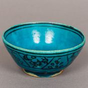 A 19th century Persian pottery bowl With black floral decoration on a turquoise ground,