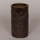 A Chinese carved bamboo brush pot Decorated in the round with boats and pagodas amongst a