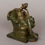 A patinated bronze figure Modelled as a young lady reclining semi-naked on an upholstered armchair.