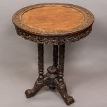 A 19th century Chinese carved tripod table The removable dished circular top carved with scrolling