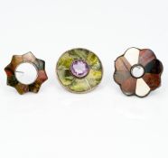 Three Scottish hardstone set silver brooches One centrally set with an amethyst.