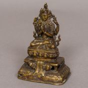 A small Sino-Tibetan figure of Buddha The four-armed deity modelled seated. 10.5 cm high.